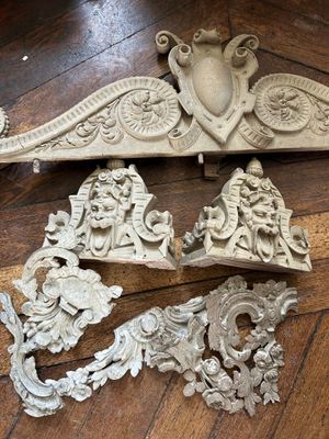 plusieurs pièces de bois sculpté sont posées sur un plancher en bois