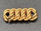 a close up of a gold bracelet on a black surface