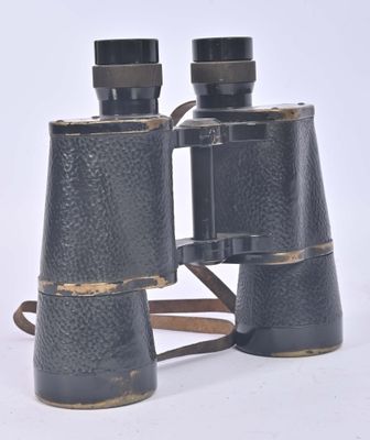 an old pair of black binoculars sitting on top of a white surface