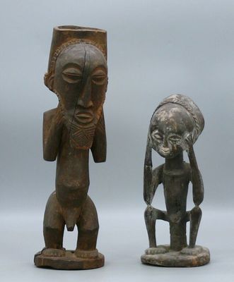 two wooden statues of a man and a woman on a white surface