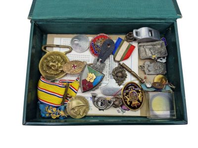 a green box filled with assorted medals and other items