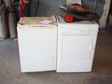 une machine à laver et un sèche-linge blancs dans un garage