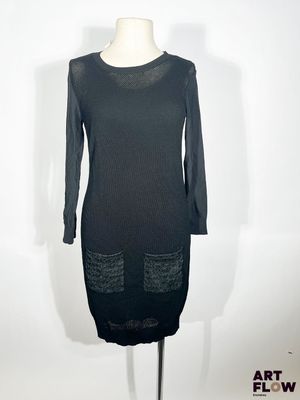 La robe est noire et a des manches longues.