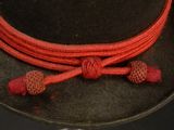 a black hat with a red rope around it