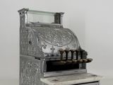 an old fashioned cash register sitting on top of a white counter
