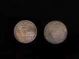 two coins are shown side by side on a black background