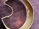 un gros plan d'un collier en forme de croissant posé sur un fond violet