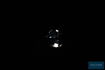 a close up of a diamond in the dark with a light shining on it