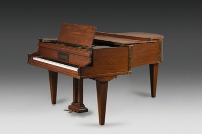 un vieux piano avec un meuble en bois posé sur une table