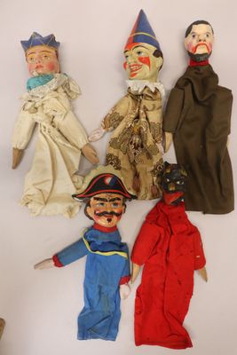several old dolls are lined up in a row on a white surface