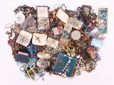 a pile of assorted jewelry on a white surface