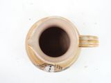 a small cup with a handle on a white surface