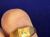 une chevalière en or au doigt d'une personne