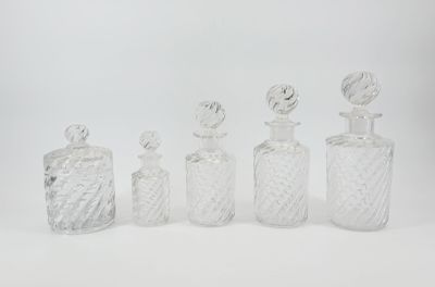 four glass bottles with a stopper and a stopper on a white surface