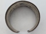 a close up of a silver bracelet on a white surface