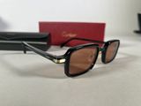 black and gold sunglasses with brown lenses on a white surface