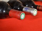 several bottles of wine are lined up on a red table