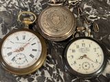 trois types différents de montres de poche posées sur une surface en marbre