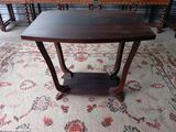 une petite table avec un plateau en bois sur un tapis