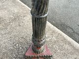 an umbrella that is sitting on a pole on the sidewalk