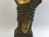 statue d'une femme coiffée d'un chapeau, posée sur un socle en bois