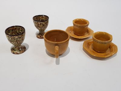 quatre tasses et soucoupes posées sur une table blanche