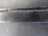 a close up of a knife on a mesh surface