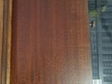 a close up of a wooden table with a keyboard in the background
