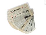 several newspapers are stacked on top of each other on a white surface