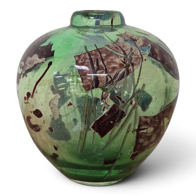 a green vase with a picture of a boat on it