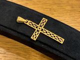 black and gold tie bar with a cross on it on a wooden table