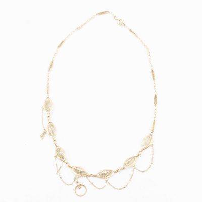 a gold necklace with leaves and beads on a white background