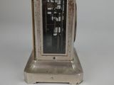 a silver clock that is sitting on a table