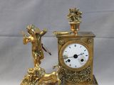 a gold clock with a statue of an angel next to it