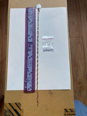 une boîte posée sur un plancher en bois, avec une règle dessus