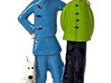 two figurines of a man and a woman with a dog