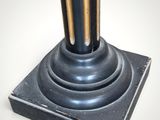 a metal pole with a black base on a white background