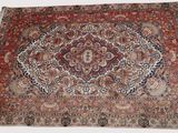 un tapis oriental avec un motif de médaillon sur fond blanc