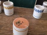 five cups sitting on a wooden table with a chalk board in the background