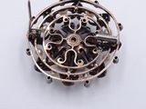 a picture of a brooch that is on a white surface