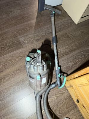un aspirateur posé par terre à côté d'une commode