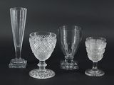 quatre vases en verre et un verre à vin sur fond noir