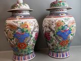 une paire de vases chinois ornés de motifs colorés, posés sur une étagère