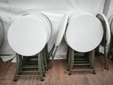 trois chaises pliantes blanches placées les unes à côté des autres sur un parquet