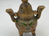 an ornate brass teapot with a bird on top of it