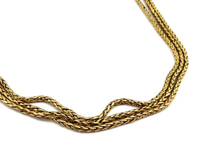 gros plan d'un collier en or sur fond blanc