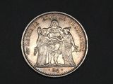 a close up of a coin on a black surface with a black background