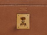 the handle of a brown leather purse with a gold clasp