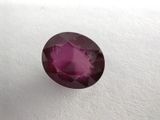 a close up view of a pink sapphire stone on a white surface