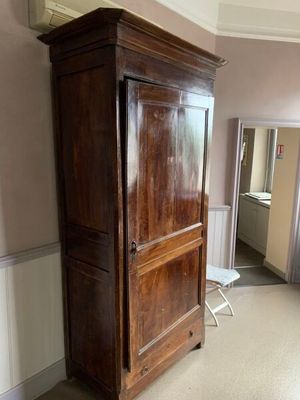 un grand meuble en bois dans le coin d'une pièce